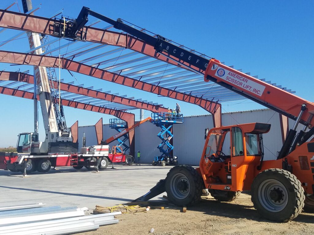 JLG telehandler and Genie scissor lifts erecting a pre-engineered steel building