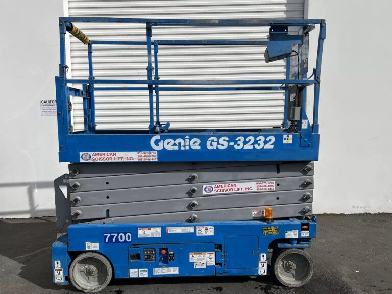 Used 2014 blue Genie GS-3232 electric scissor lift with its platform lowered in front of an American Scissor Lift building