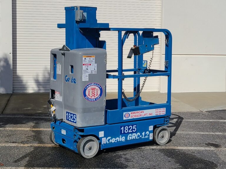 Used 2015 blue Genie GRC-12 self-propelled vertical mast lift with its mast lowered in front of an American Scissor Lift building