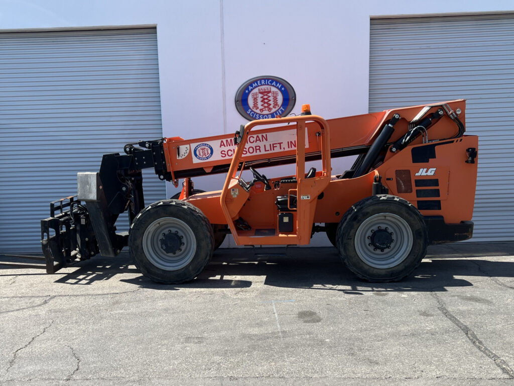 Used 2015 orange SkyTrak 10054 telehandler with fork carriage, parked in front of a warehouse, from the American Scissor Lift rental fleet